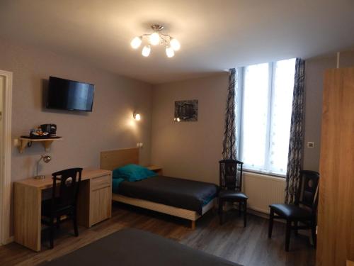 a bedroom with a bed and a desk and a window at Le Lion D'or in Ouroux en Morvan