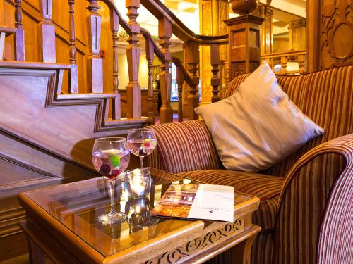 a table with two glasses of wine on a couch at Lady Gregory Hotel, Leisure Club & Beauty Rooms in Gort