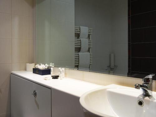 bagno con lavandino e specchio di Lady Gregory Hotel, Leisure Club & Beauty Rooms a Gort