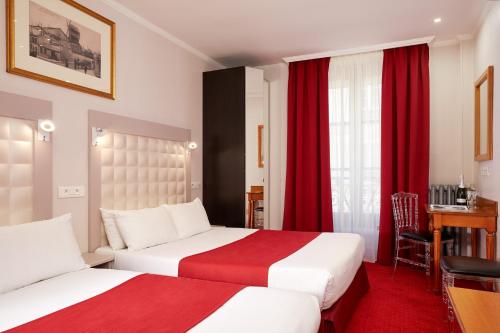 2 letti in camera d'albergo con tende rosse di Grand Hôtel Amelot a Parigi
