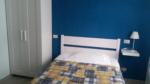 a blue bedroom with a bed with a checkered blanket at Hotel Ristorante El Caracol in Mulazzo