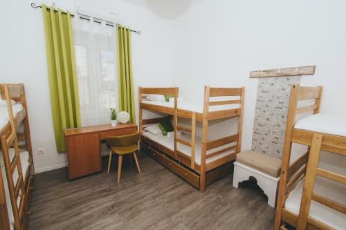 a dorm room with bunk beds and a desk and a desk at Hostel Globo in Šibenik