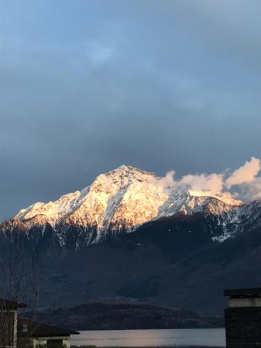 a snow covered mountain with a lake in front of it at Residenza Christian in Gravedona