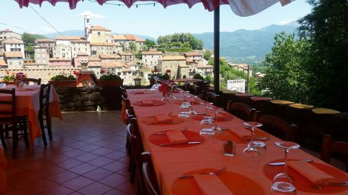 a long table with red plates and wine glasses at Hotel Ristorante El Caracol in Mulazzo