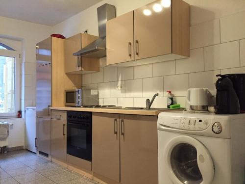 uma cozinha com uma máquina de lavar roupa e um lavatório em Hannover Südstadt - Zimmer und Apartment em Hanôver