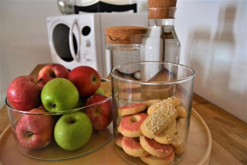a table topped with two bowls of apples and cookies at Solsta Hotell in Karlstad