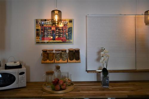 a kitchen with a table with a bowl of fruit and a microwave at Solsta Hotell in Karlstad