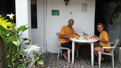 un homme et une femme assis à une table dans l'établissement Hostal L'Auberge Inn, à Quito