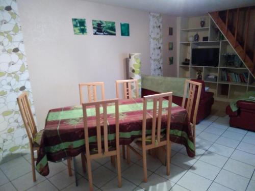 a dining room with a table and chairs and a tv at les tourterelles in Chabournay
