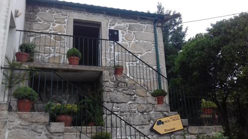 a stone building with potted plants on a balcony at Residencial Retiro Sra. da Luz in Ponte de Lima
