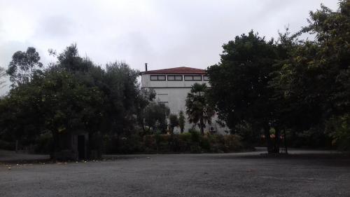 a large white building with trees in front of it at Residencial Retiro Sra. da Luz in Ponte de Lima