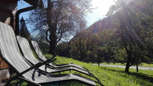 a park bench sitting in the grass near a road at Ferienhaus Hirschnest in Sankt Pankraz