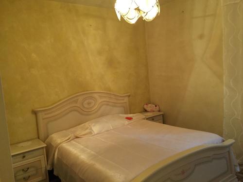 a bedroom with a white bed and a chandelier at Casa Gravere in Gravere