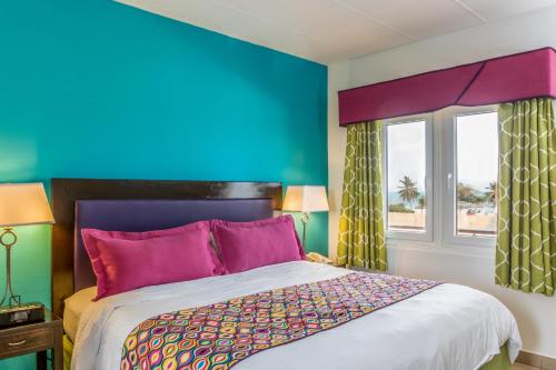 a bedroom with a bed and a blue wall at MVC Eagle Beach in Palm-Eagle Beach