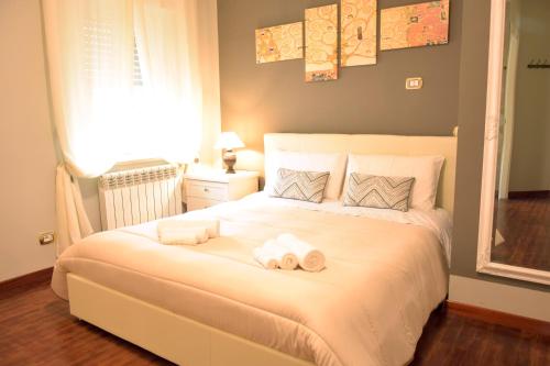 a bedroom with a large white bed with towels on it at Tortuga in Sassari