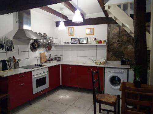 Caunes-MinervoisにあるAnglaiseのキッチン(赤いキャビネット、洗濯機付)