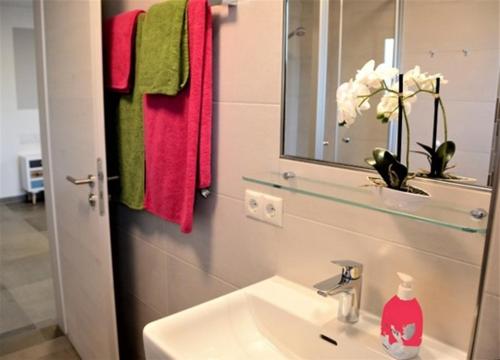 a bathroom with a sink and a mirror and towels at Gästehaus Brunnerhof - Eitting in Eitting
