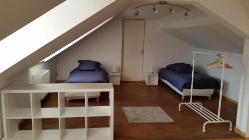 - une chambre mansardée avec 2 lits et un escalier dans l'établissement Le Clos de Ramousies, à Ramousies