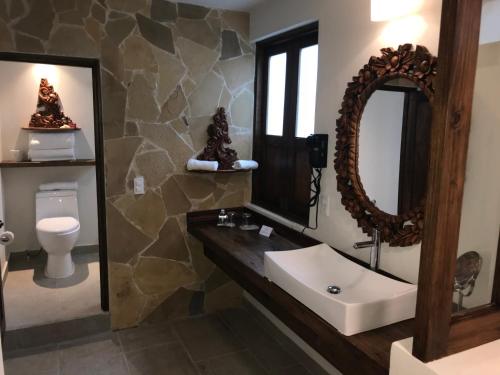 La salle de bains est pourvue d'un lavabo, d'un miroir et de toilettes. dans l'établissement Hotel Grand Maria, à San Cristóbal de Las Casas