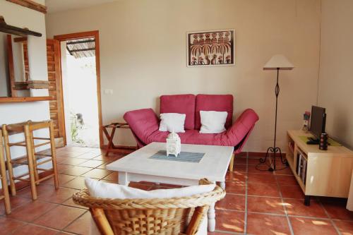 a living room with a red couch and a table at Casa Montecote Eco Resort in Vejer de la Frontera