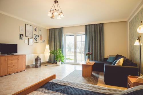 a living room with a couch and a tv at Paradise in Charzykowy