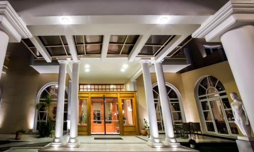 a lobby with white columns and a glass door at Kouros Hotel in Drama