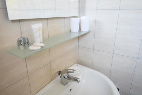 a bathroom with a sink and a glass shelf at Chiaralice in Noto