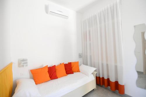 a white couch with orange pillows in a room at Chiaralice in Noto