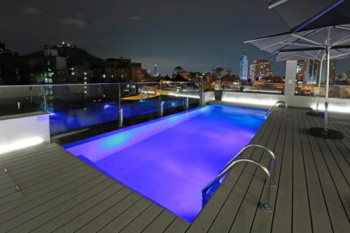 a swimming pool on the roof of a building at night at Hotel Cumbres Lastarria in Santiago