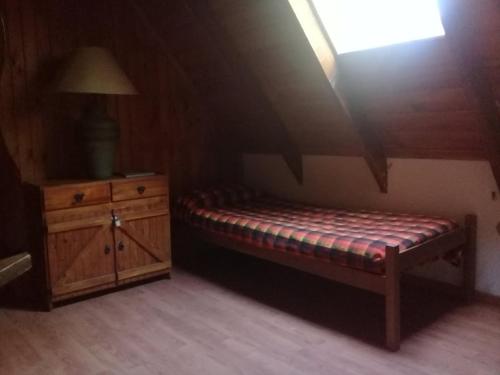 Habitación con cama, cómoda y lámpara. en Casa Los Robles, en San Martín de los Andes