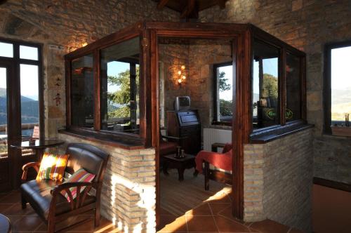 a living room with windows and a chair and a desk at Georgio's V Chalet Kalavrita in Kalavrita