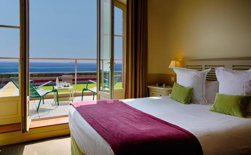 a bedroom with a large bed and a balcony at Le Grand Large, Belle-Ile-En-Mer in Bangor