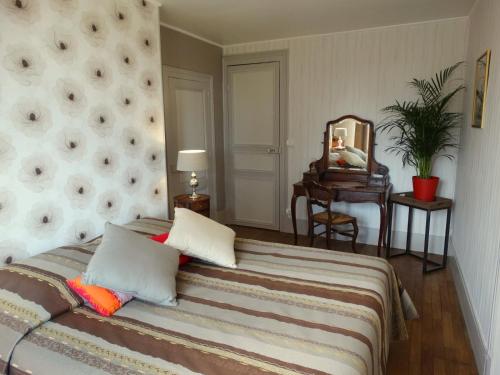 ein Schlafzimmer mit einem großen Bett und einem Spiegel in der Unterkunft B&B Girolles les Forges in Girolles