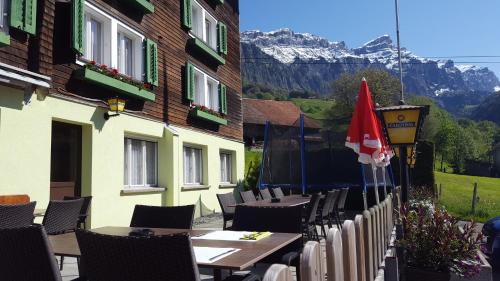 a restaurant with tables and chairs in front of a building at Hotel Alpenblick Muotathal in Muotathal
