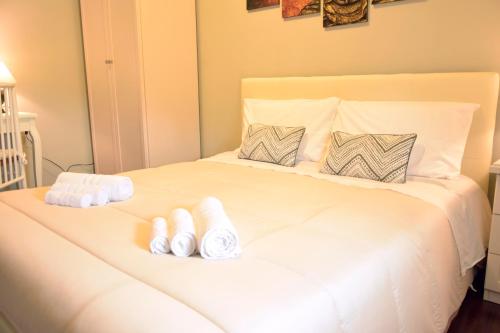 a white bed with two rolled towels on it at Tortuga in Sassari