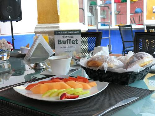 un tavolo con un piatto di frutta e un cestino di pane di Hotel Malinalli a Huamantla
