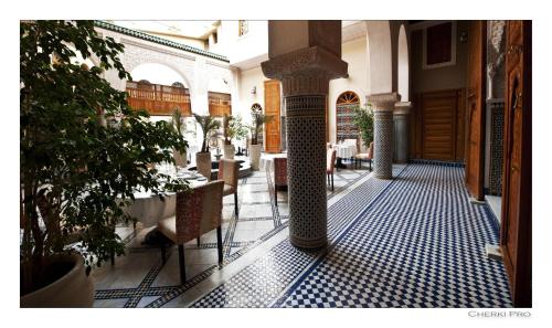 a hallway with chairs and tables in a building at Riad Andalib in Fès