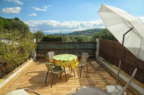 a patio with a table and chairs and an umbrella at Casa Montecote Eco Resort in Vejer de la Frontera