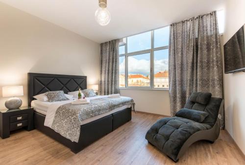 a bedroom with a bed and a chair and a window at PRIMA Life Spalato in Split