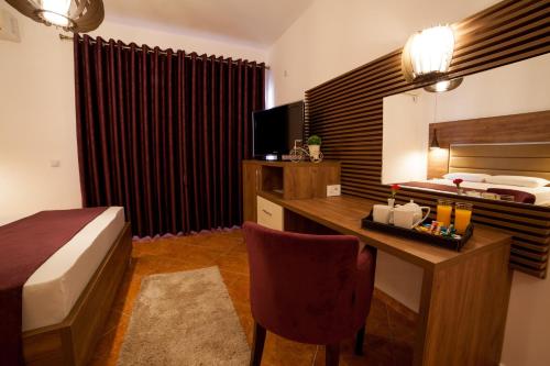 a hotel room with a bed and a desk and a bedroom at Guest House Pasha in Ulcinj