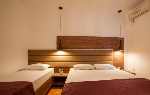 a bedroom with two beds and a head board at Guest House Pasha in Ulcinj