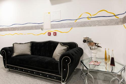 a black couch in a living room with a table at PRIMA Life Spalato in Split