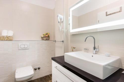 a white bathroom with a sink and a toilet at PRIMA Life Spalato in Split