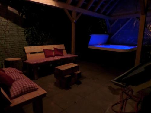 a dark room with a bench and a blue light at Bungalow met privé jacuzzie in Lunteren