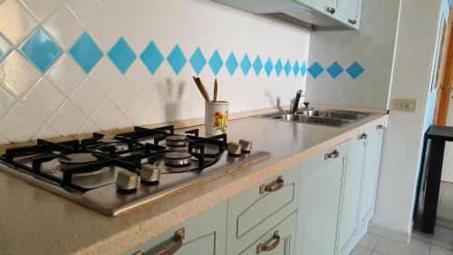 a kitchen with a stove and a sink at Residenze Coda Cavallo in San Teodoro