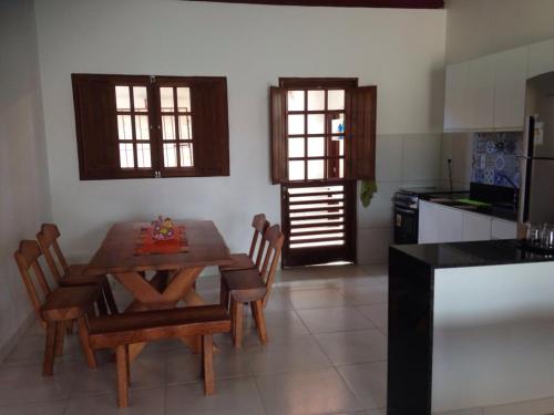 a kitchen with a wooden table and chairs in a room at Casa em São Miguel dos Milagres - 700m do mar in São Miguel dos Milagres