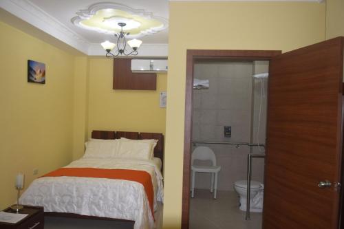 a bedroom with a bed and a bathroom with a shower at Olan´s Hotel Group in Esmeraldas