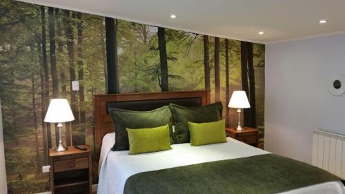 1 dormitorio con 1 cama con un mural de bosque en la pared en Hotel Puerta del Lago, en Puerto Varas