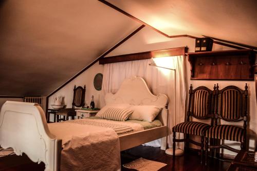 クシロカストロにあるVilla Manoのベッドルーム1室(ベッド1台、屋根裏部屋の椅子付)
