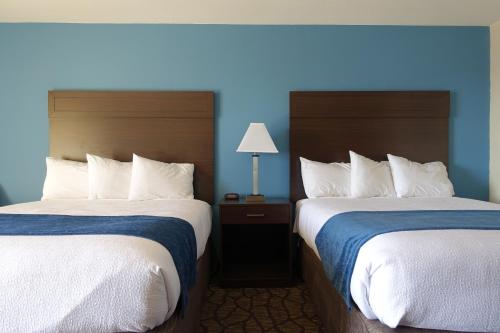 two beds in a hotel room with blue walls at Harborside Inn in Port Townsend